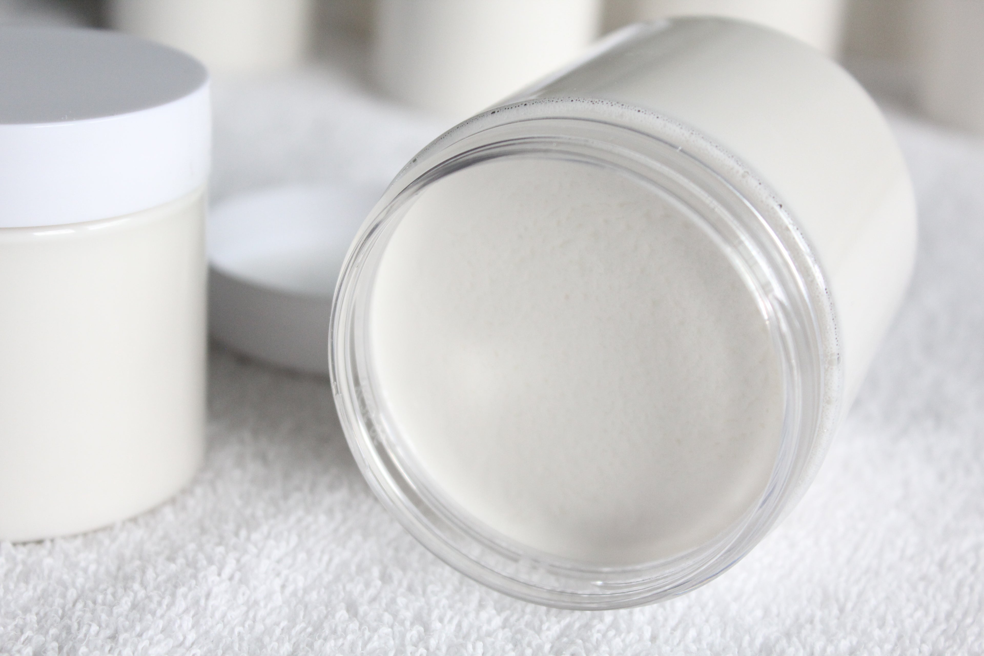 Close-up of a white container with a clear lid on a textured surface