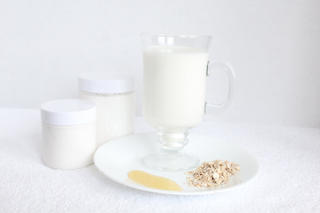 Glass of milk with a plate of oatmeal and a container on a white background