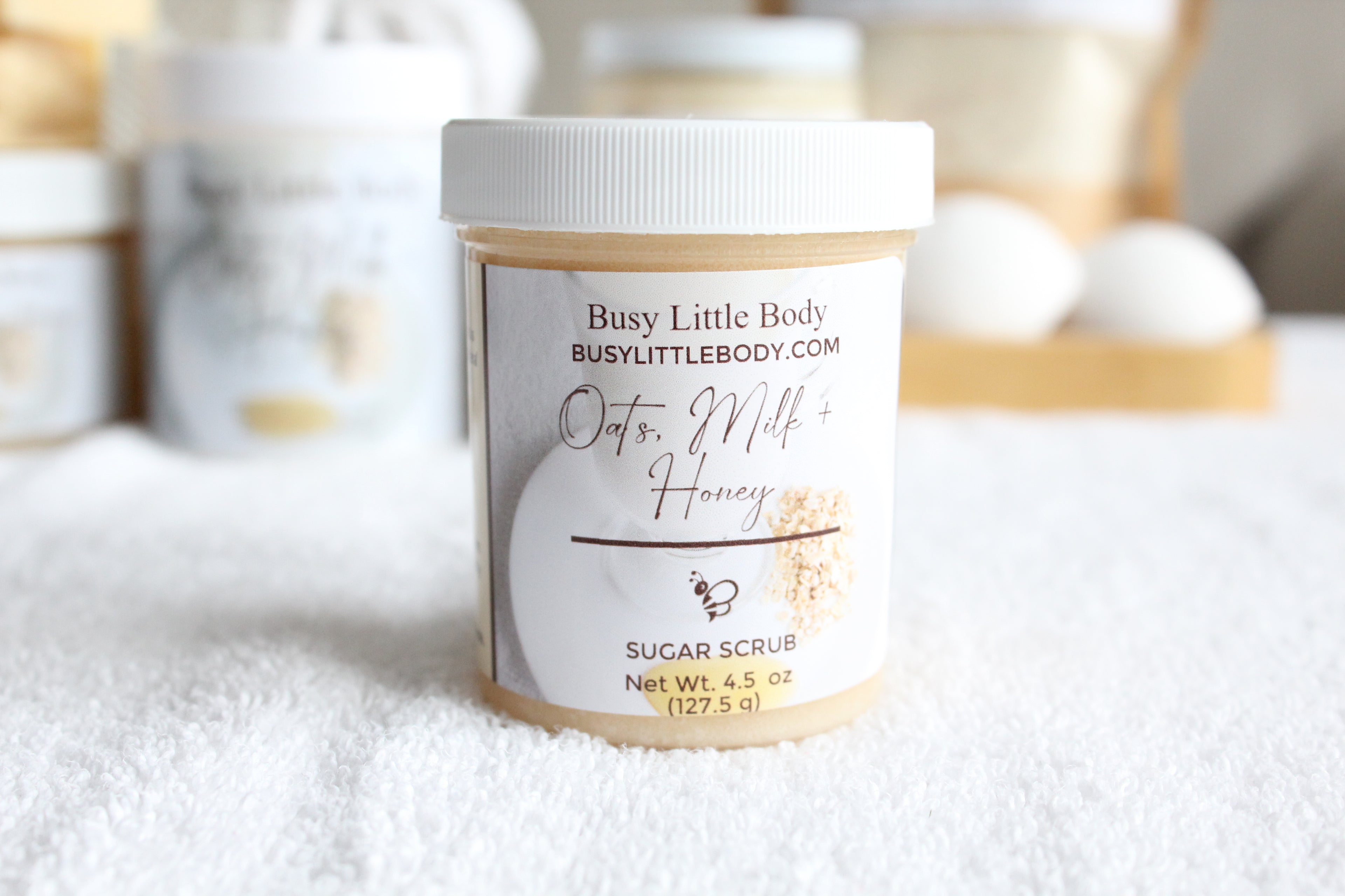Jar of Busy Little Body Oats, Milk & Honey Sugar Scrub on a white surface