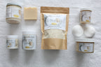 Collection of 'Busy Little Body' skincare products on a textured surface