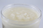 Jar of white sugar scrub on a light gray background