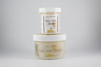 Two jars of 'Oats, Milk + Honey' body product on a gray background