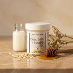 Jar of 'Oats, Milk + Honey' body butter on a gray background
