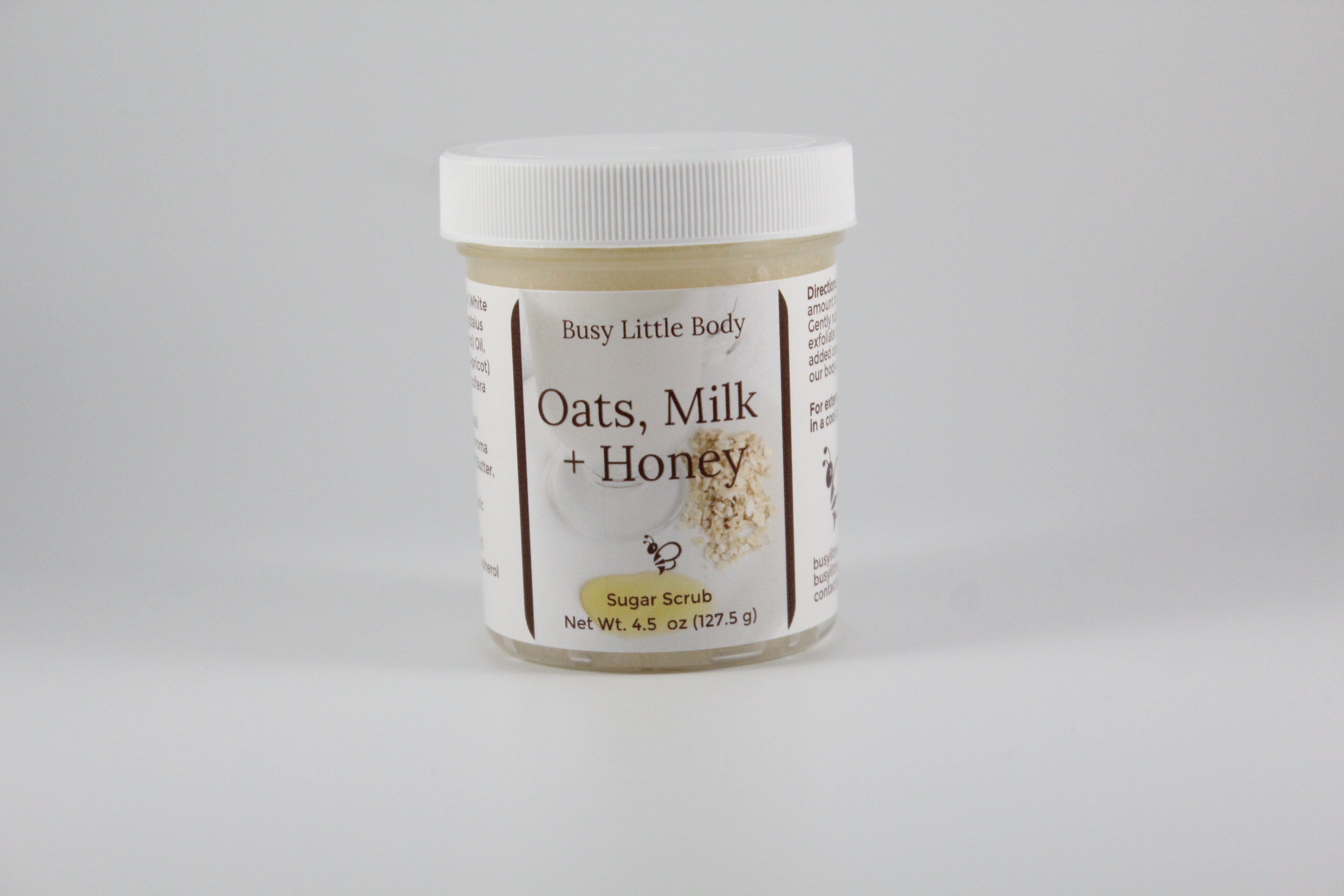 Jar of 'Oats, Milk + Honey' body butter on a gray background