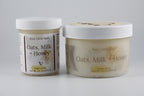 Two jars of 'Oats, Milk + Honey' sugar scrub by Busy Little Body on a gray background