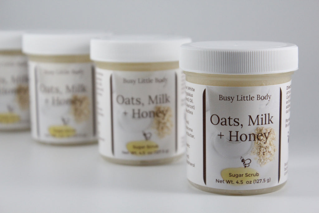 Jars of Busy Little Body Oats, Milk + Honey sugar scrub on a white background