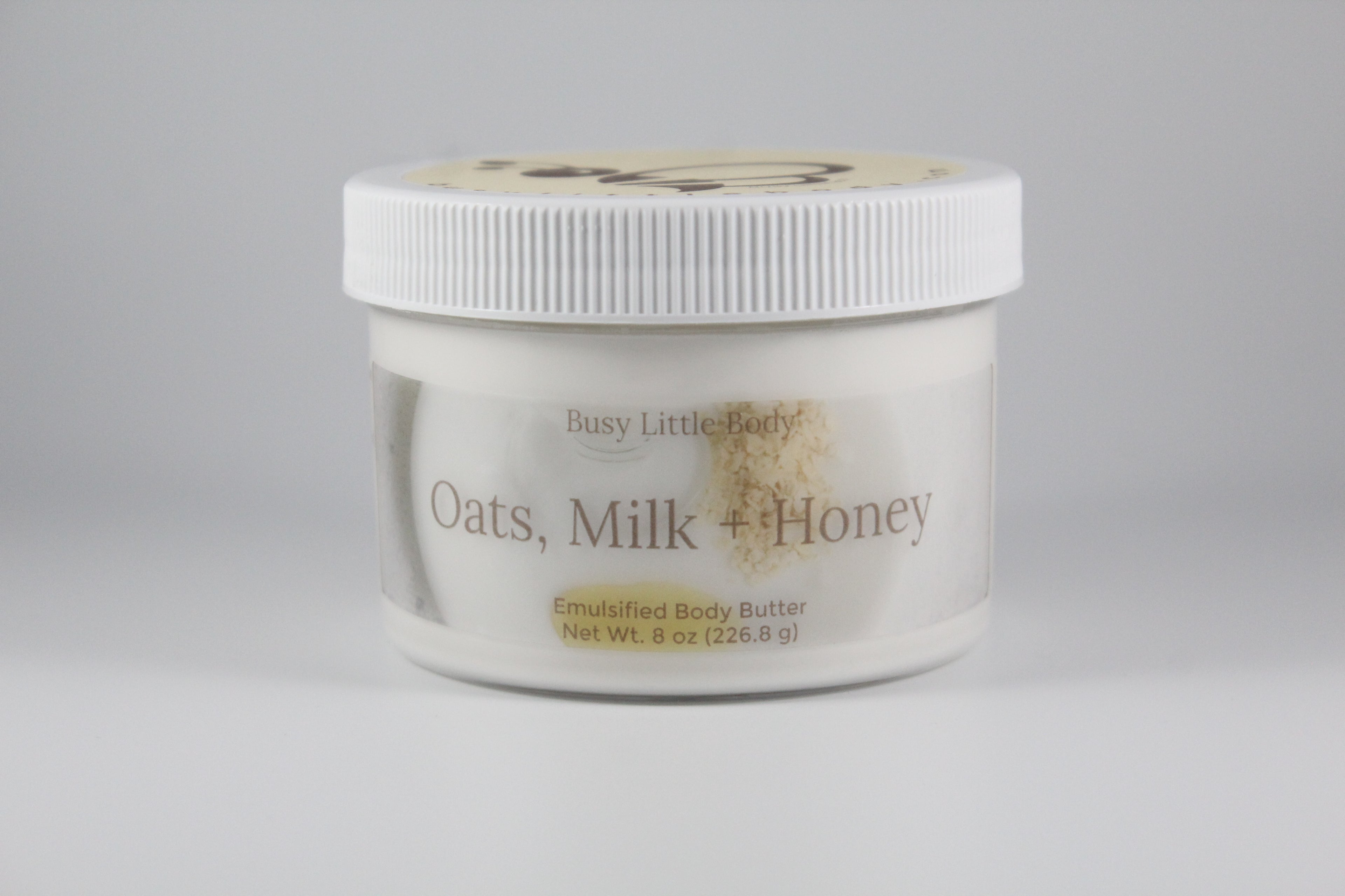 Jar of 'Oats, Milk + Honey' emulsified body butter on a gray background
