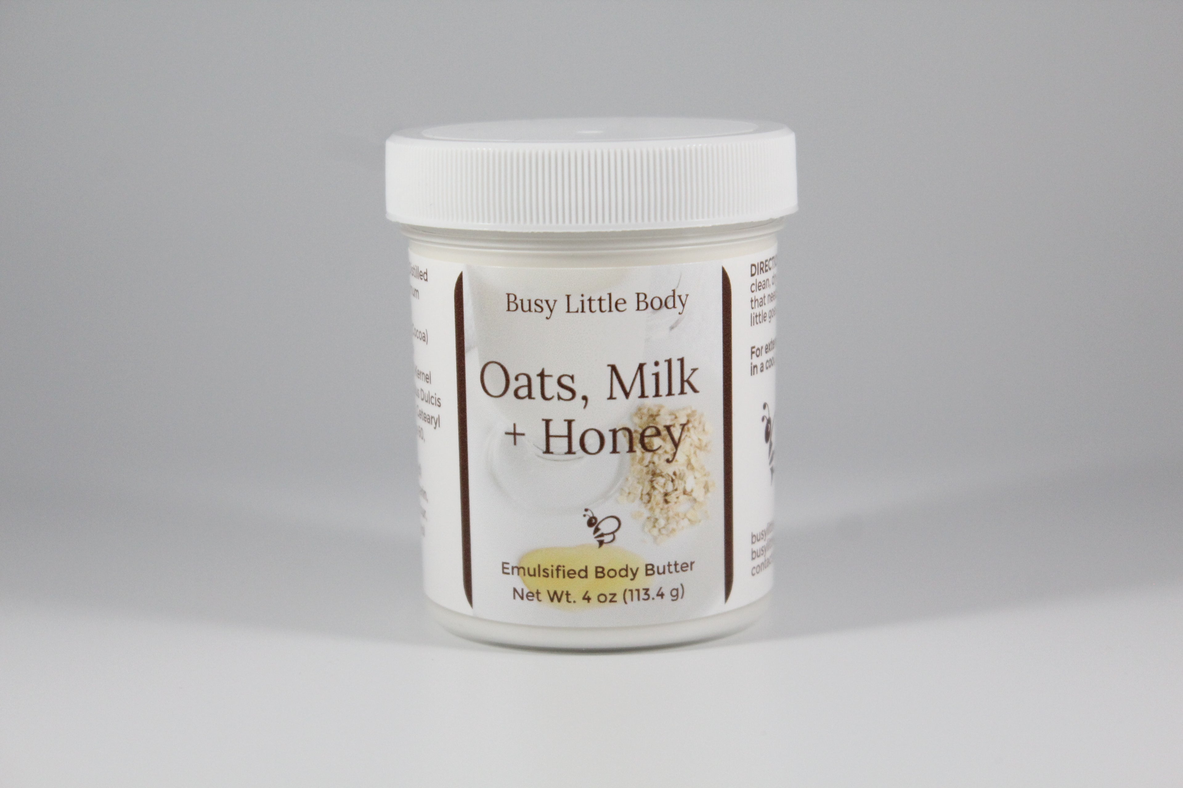 Jar of 'Oats, Milk + Honey' body butter by Busy Little Body on a gray background