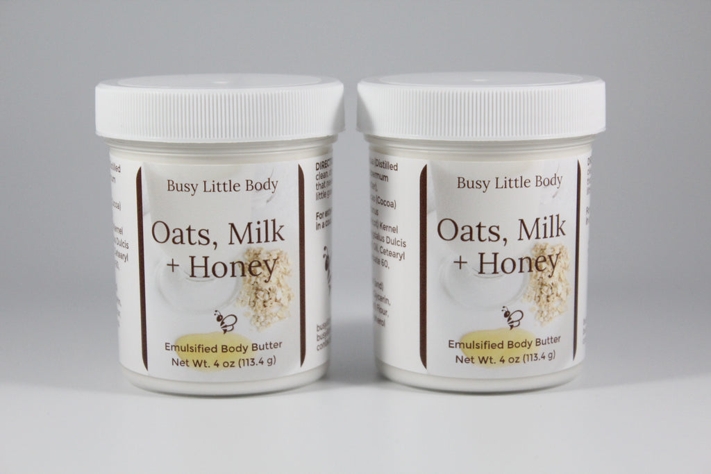 Two jars of 'Oats, Milk + Honey' body butter by Busy Little Body on a gray background
