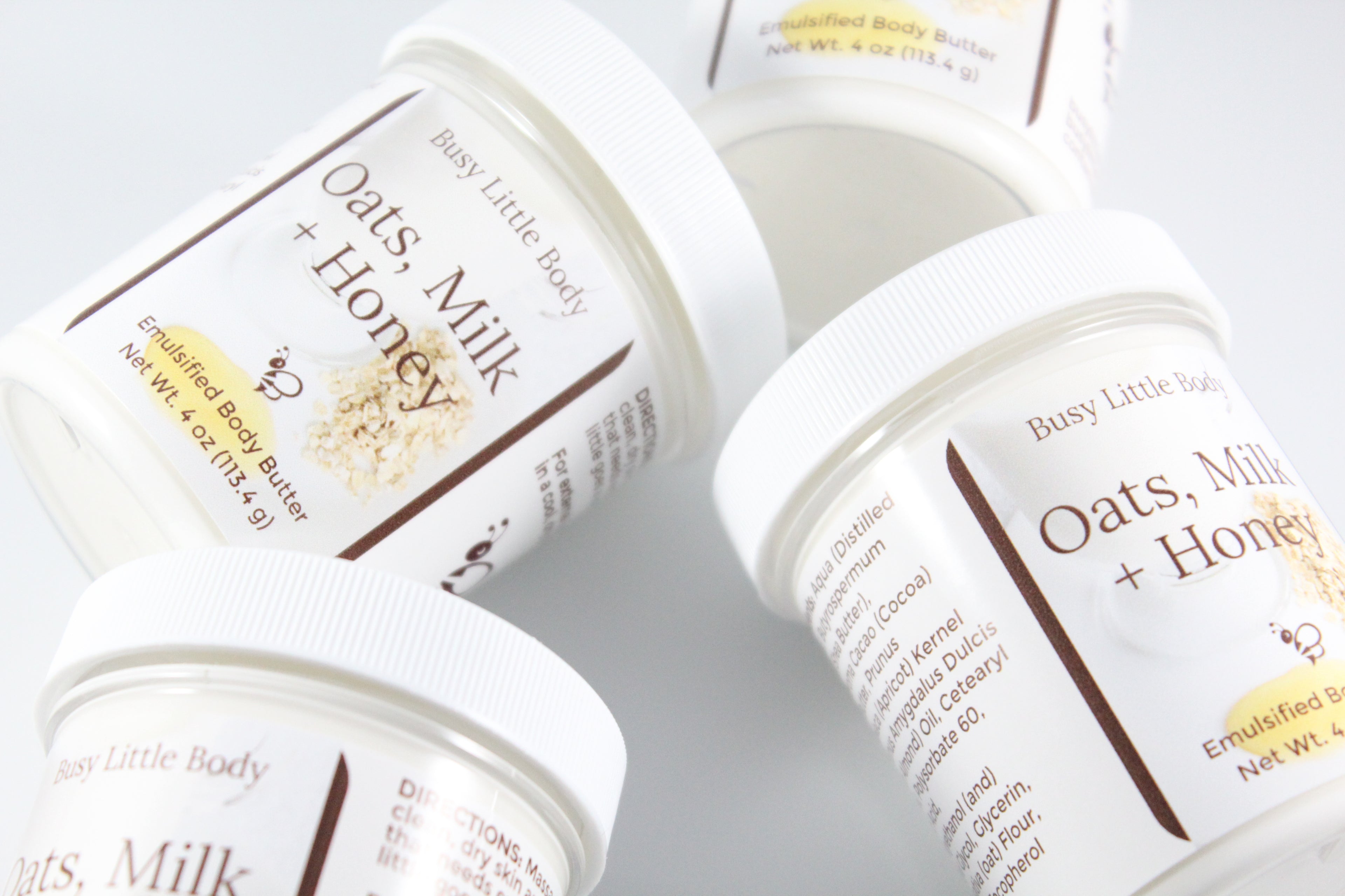 Jars of 'Oats, Milk + Honey' body butter from Busy Little Body on a light background