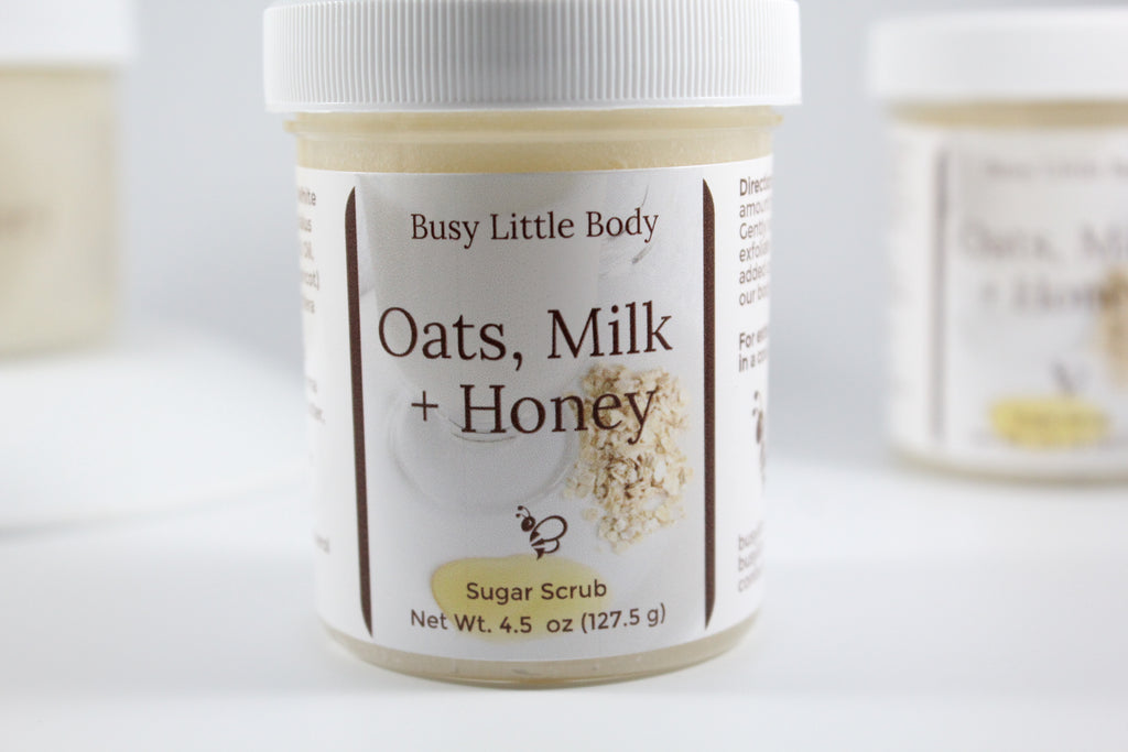 Jar of 'Oats, Milk + Honey' sugar scrub with a label on a white background