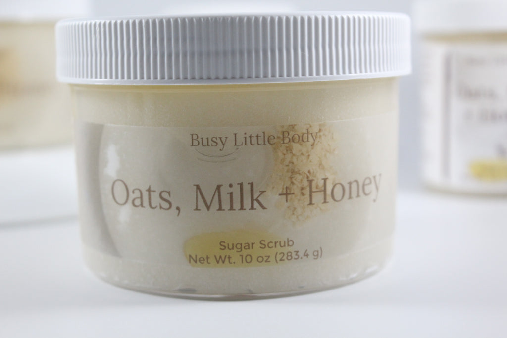 Jar of 'Oats, Milk + Honey' sugar scrub with 'Busy Little Body' branding on a white background.