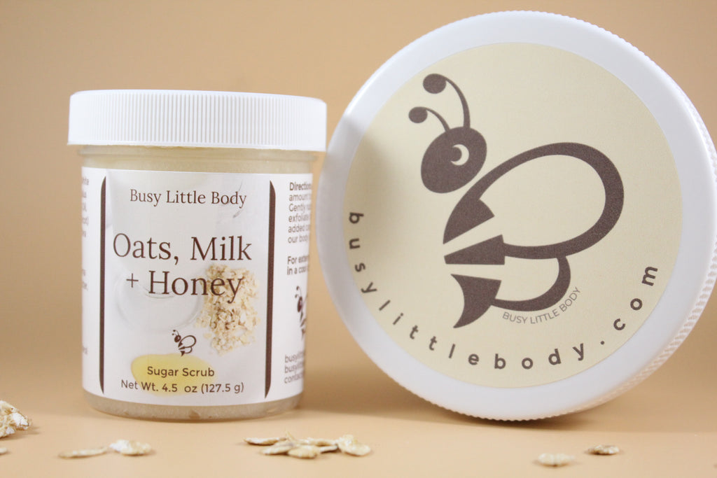 Oats, Milk + Honey sugar scrub jar with lid on a beige background
