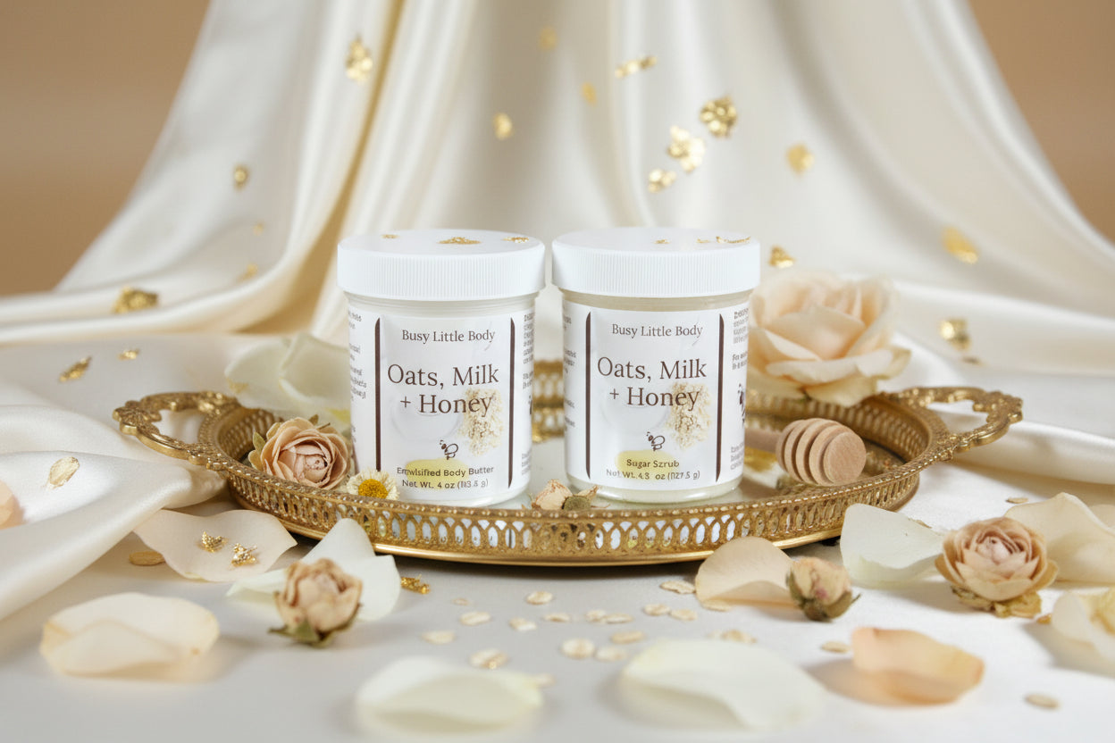 two jars of the goddess duo, a sugar scrub and a body butter with flowers, linen and a tray. cream background.