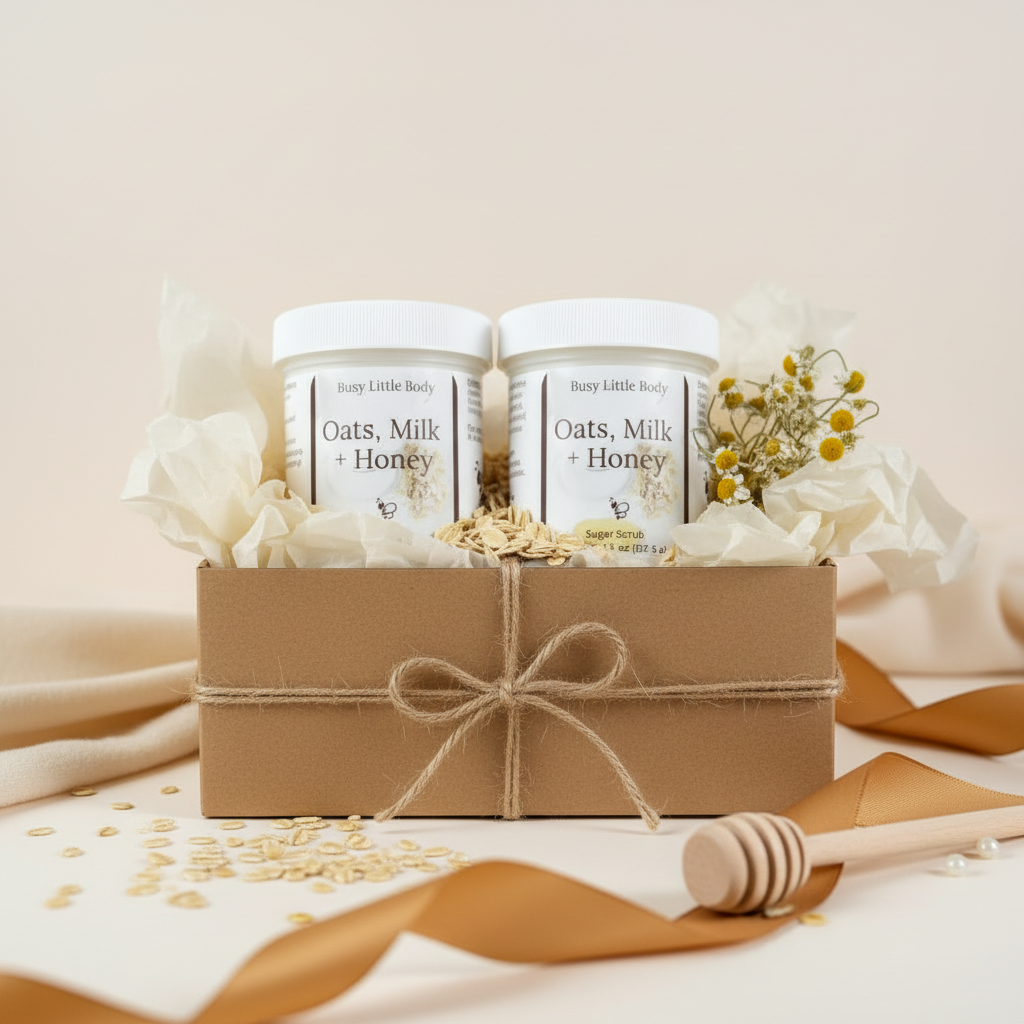 Two jars of 'Oats, Milk + Honey' product in a decorative box with oats and a honey dipper on a light background.
